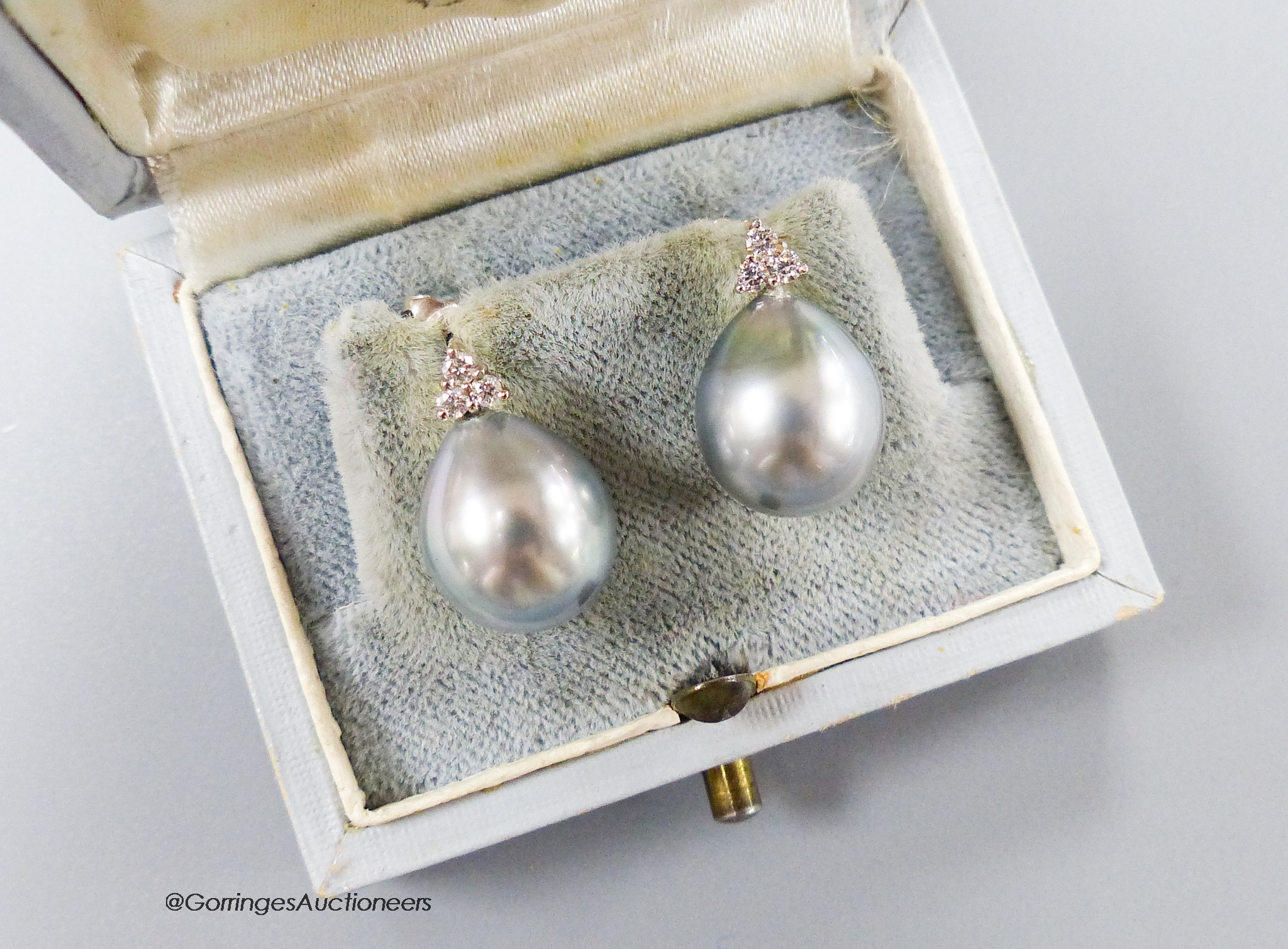 A pair of white metal, cultured Tahitian pearl and diamond cluster set earrings, pearl diameter approx. 10.7mm, gross 5.1 grams.